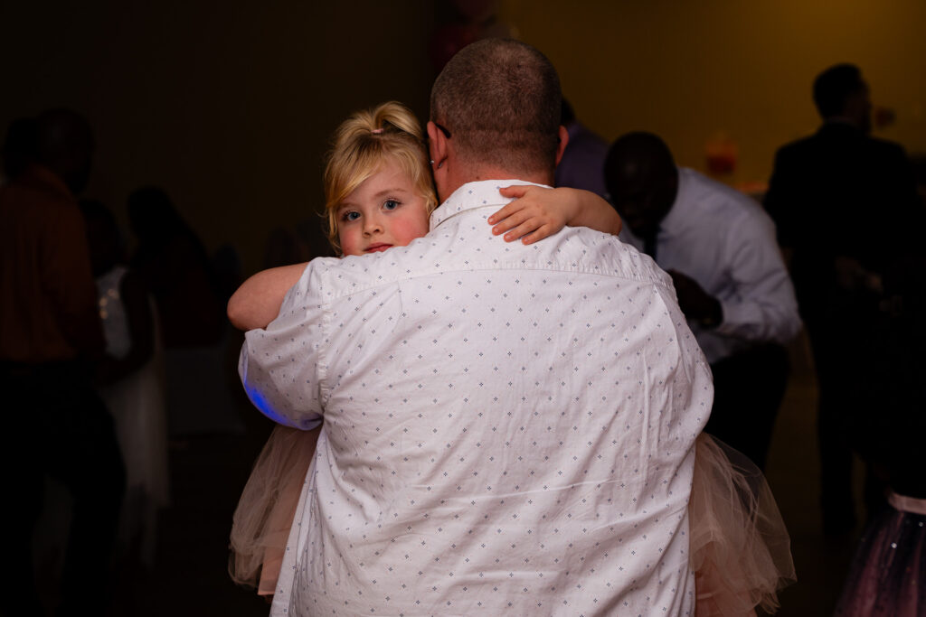 Father and daughter enjoying a joyful dance at a memorable celebration event.