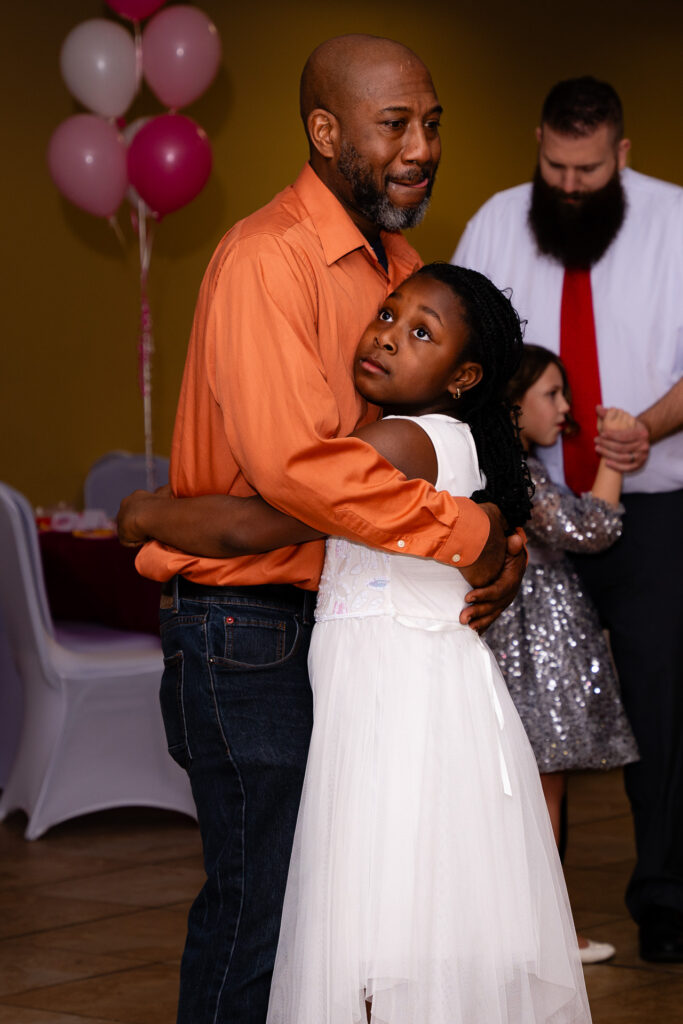 Father and daughter enjoying a memorable dance at a special event.