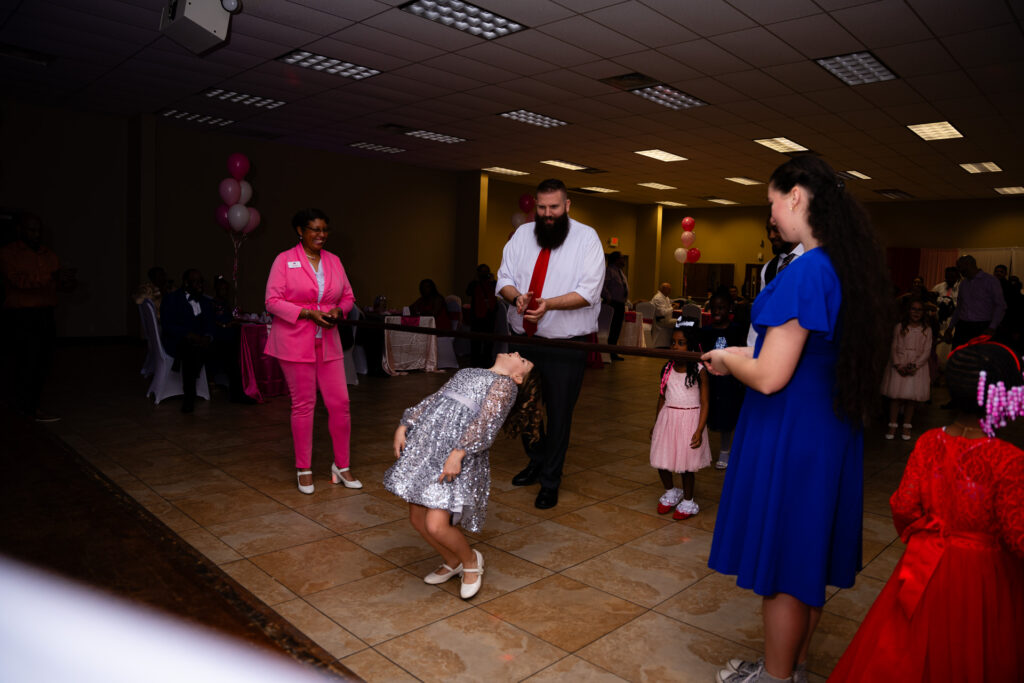 Father and daughter share a joyful dance at a special event.
