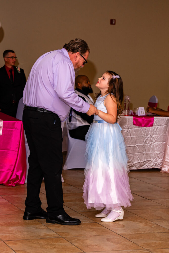 Father and daughter enjoying a memorable dance together at a special event.