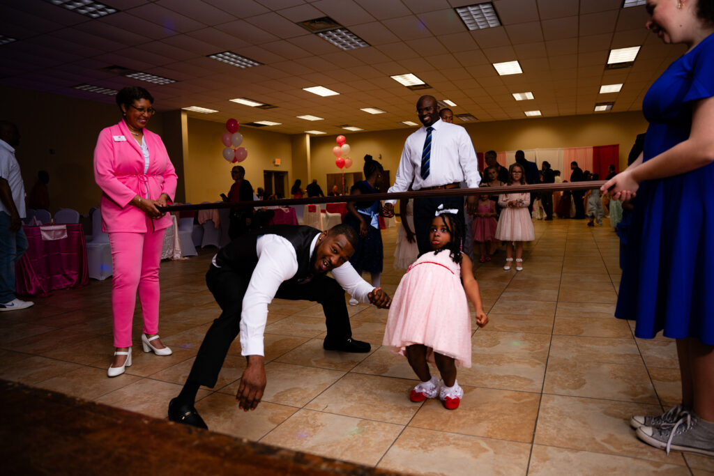 A joyful father-daughter dance moment captured at a special celebration.