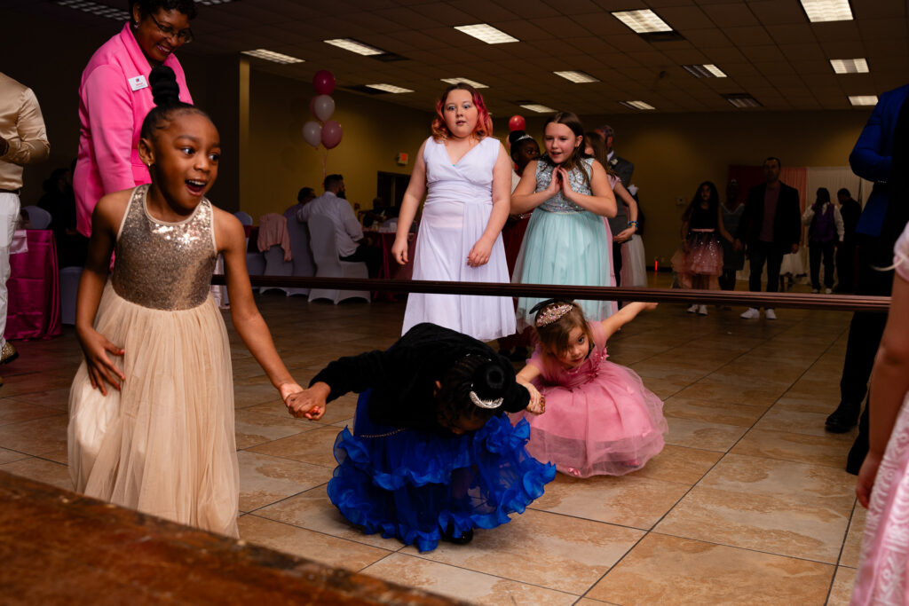 Father and daughter share a joyful dance at a special event.
